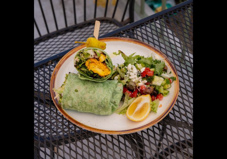 Healthy dining table featuring fresh salads, grilled vegetables, lean proteins, and nutritious whole foods in a bright restaurant setting.
