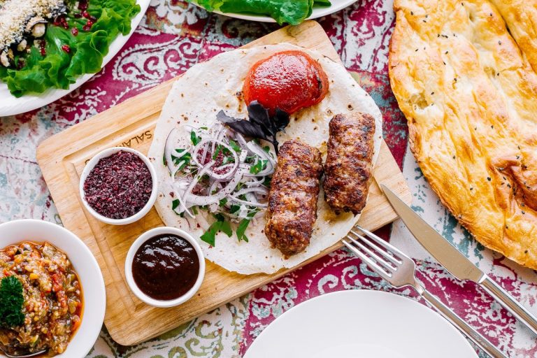 A delicious spread of authentic kebabs, fresh herbs, and golden saffron rice from Parkway, a premier persian restaurant in Southern California.