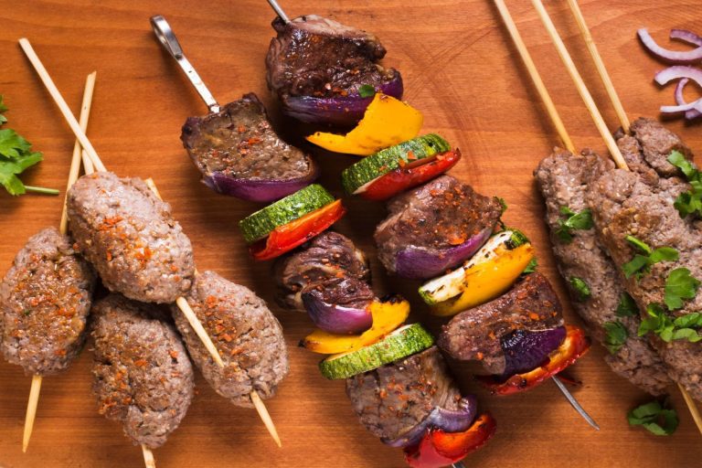 Grilled beef shish and chicken koobideh skewers served over saffron basmati rice with charred tomatoes, showcasing authentic kebab in Los Angeles.
