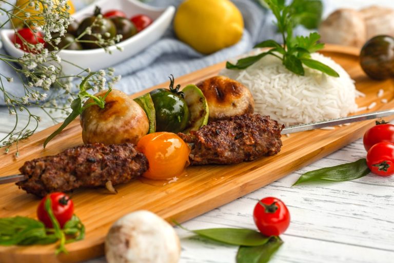 Buffet spread of Persian catering in Calabasas featuring platters of saffron basmati rice, charbroiled beef koobideh kebabs, and fresh herb appetizers at a wedding reception.