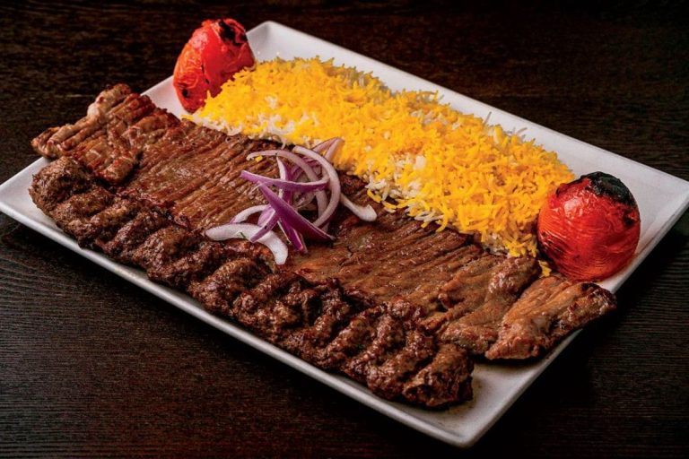 Platter showing the difference between Barg and Koobideh Persian kebabs served with saffron basmati rice and charred tomatoes.